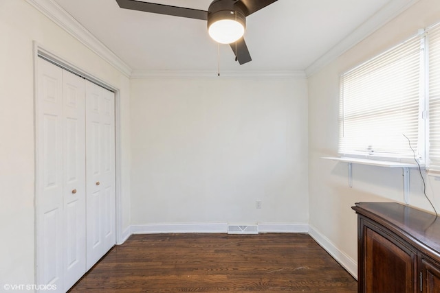 unfurnished bedroom with ceiling fan, crown molding, dark wood-type flooring, and a closet