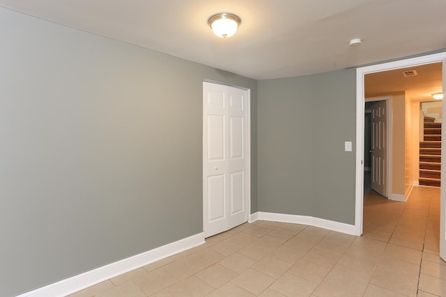 unfurnished bedroom featuring light tile patterned flooring and a closet