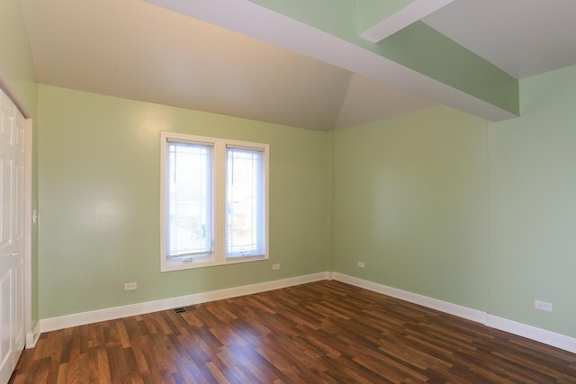 spare room with lofted ceiling and dark hardwood / wood-style floors