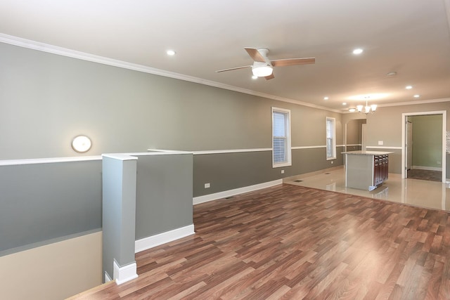 spare room featuring ceiling fan with notable chandelier, hardwood / wood-style flooring, and ornamental molding