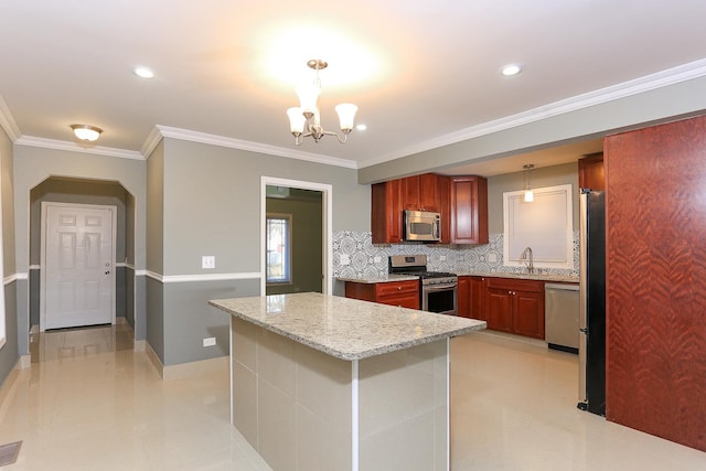 kitchen featuring decorative light fixtures, light stone counters, appliances with stainless steel finishes, and tasteful backsplash