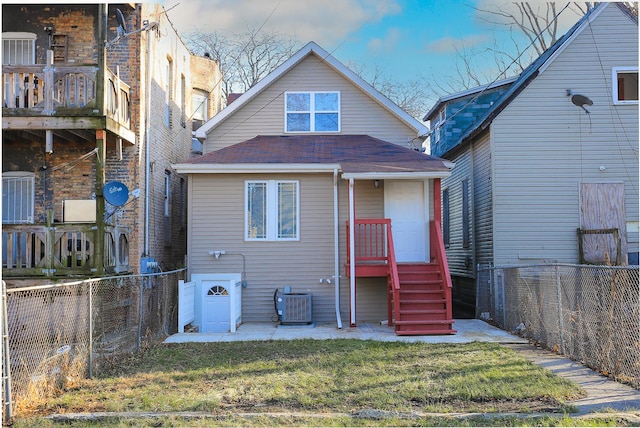 back of house featuring a yard and cooling unit