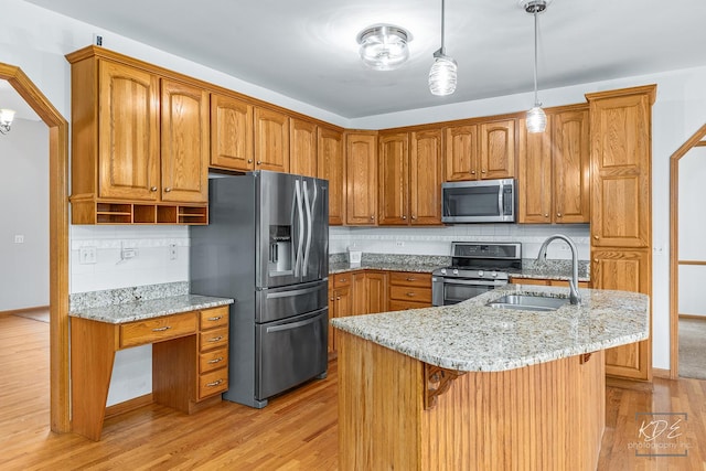 kitchen featuring backsplash, light stone counters, sink, and appliances with stainless steel finishes