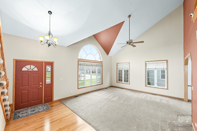 foyer featuring ceiling fan with notable chandelier, high vaulted ceiling, and light hardwood / wood-style flooring