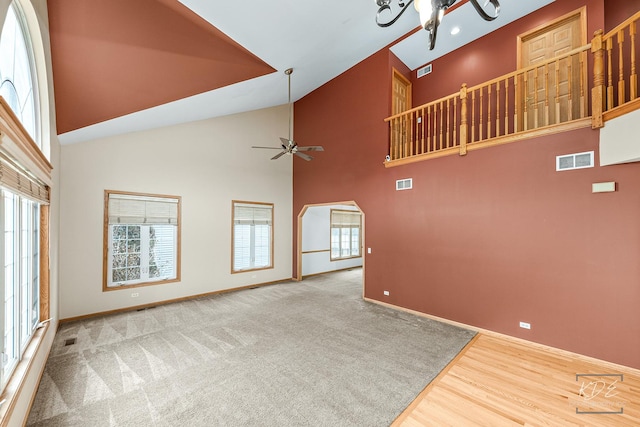 unfurnished living room with ceiling fan, high vaulted ceiling, and a healthy amount of sunlight