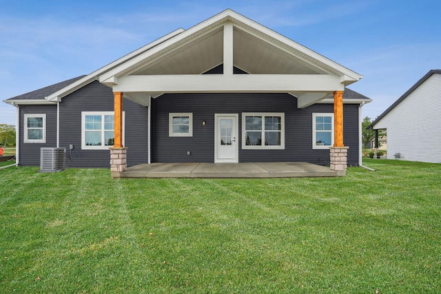 rear view of house with a lawn and central AC unit