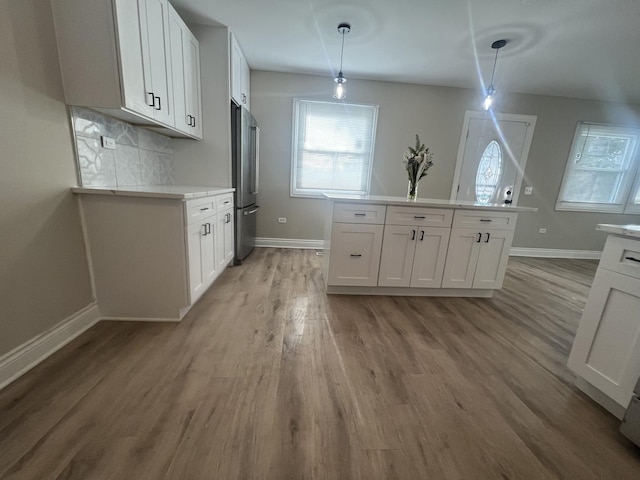 kitchen featuring pendant lighting, a center island, high end fridge, and white cabinetry