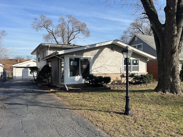 view of property exterior featuring a garage, an outdoor structure, and a lawn