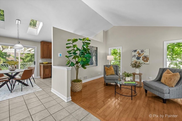1154 Dovercliff Way, Crystal Lake, IL 60014 - living area with a skylight, vaulted ceiling, healthy amount of natural light, and light tile patterned flooring