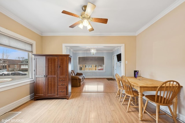 dining area with ceiling fan with notable chandelier, light wood-type flooring, and crown molding