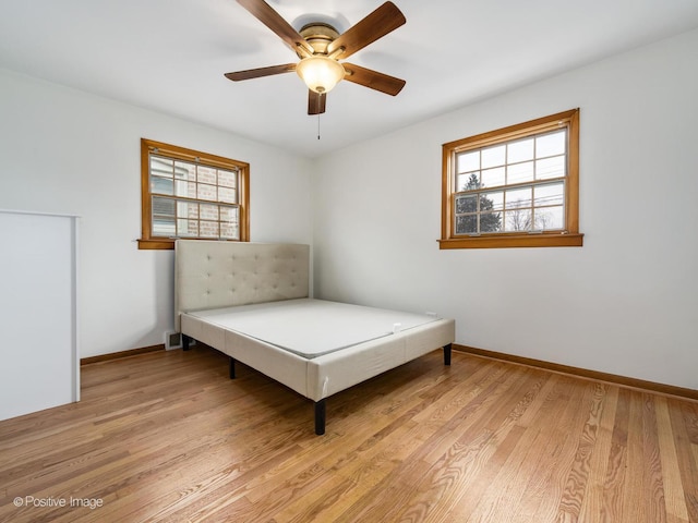 unfurnished bedroom featuring multiple windows, ceiling fan, and light hardwood / wood-style floors