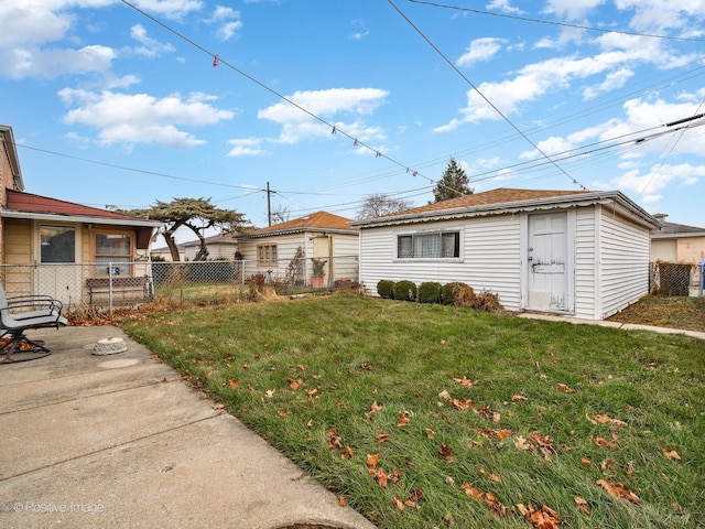 view of front of property with an outbuilding, a patio, and a front yard