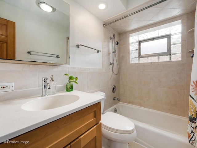 full bathroom with vanity, shower / bath combination with curtain, toilet, and tile walls