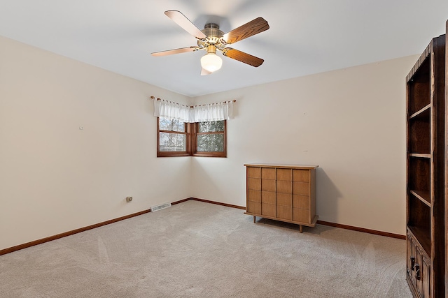 spare room featuring light carpet and ceiling fan