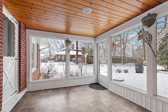 unfurnished sunroom featuring plenty of natural light and wooden ceiling