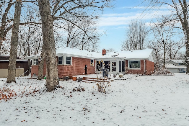 view of snow covered rear of property