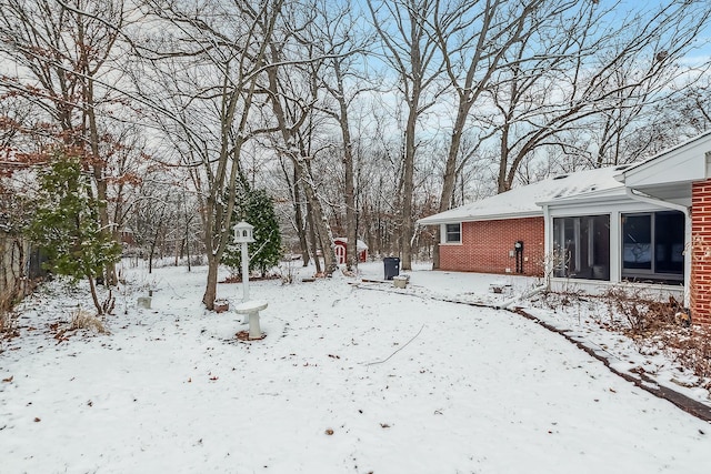 yard layered in snow with a sunroom