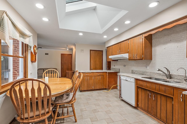 kitchen featuring dishwasher, tasteful backsplash, a skylight, and sink