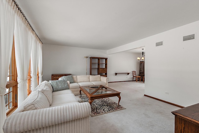 carpeted living room with a chandelier