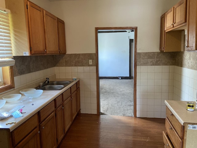 kitchen with tile walls, dark wood-type flooring, and sink