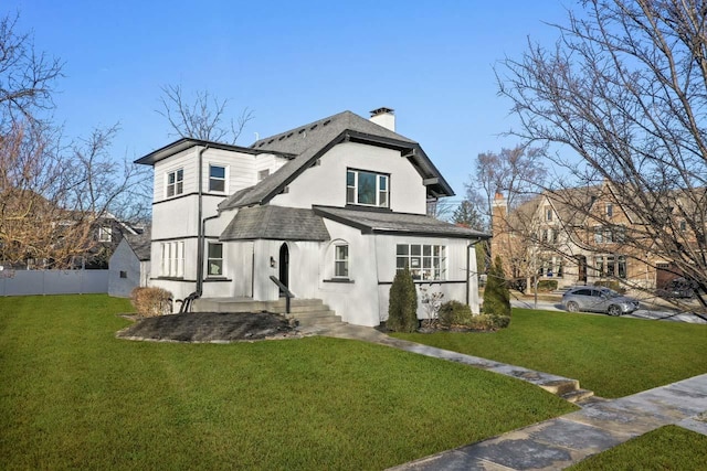 rear view of property featuring a lawn