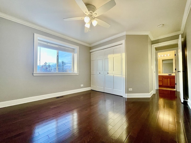 unfurnished bedroom featuring dark hardwood / wood-style flooring, a closet, ceiling fan, and ornamental molding