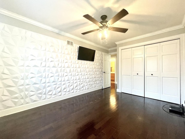 unfurnished bedroom featuring ceiling fan, a closet, crown molding, and dark hardwood / wood-style floors