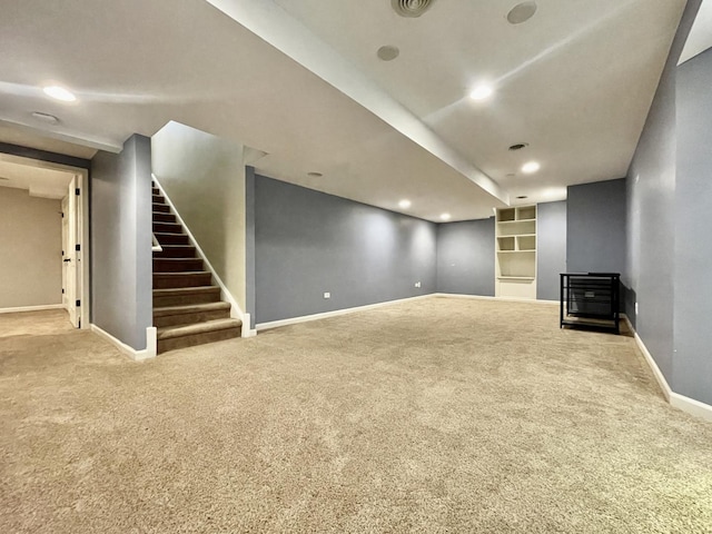 unfurnished living room featuring built in shelves and carpet floors