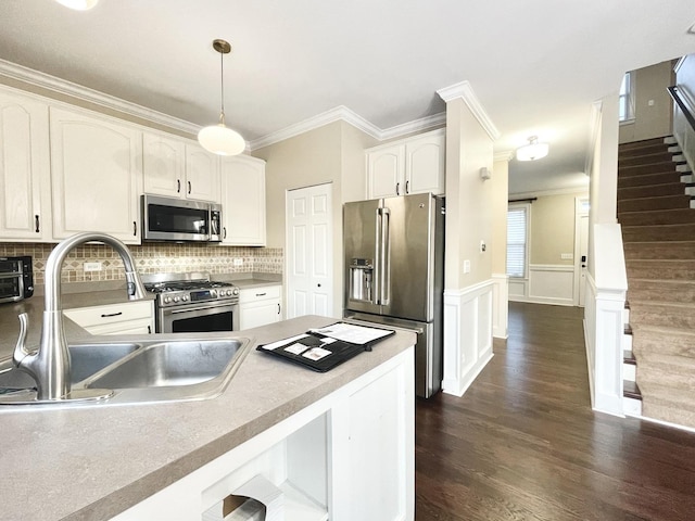 kitchen with high end appliances, sink, dark hardwood / wood-style floors, decorative light fixtures, and white cabinetry