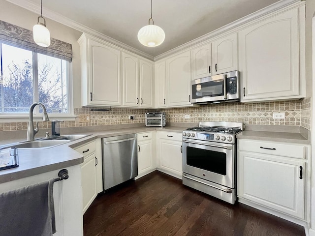 kitchen featuring appliances with stainless steel finishes, decorative light fixtures, white cabinetry, and dark wood-type flooring