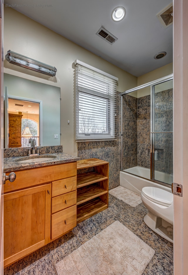 full bathroom featuring vanity, toilet, and enclosed tub / shower combo