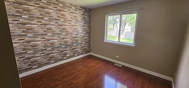 empty room with dark hardwood / wood-style flooring