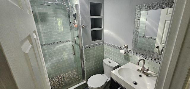 bathroom featuring an enclosed shower, toilet, sink, and tile walls