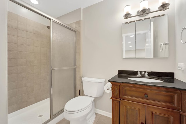 bathroom featuring tile patterned floors, vanity, a shower with shower door, and toilet