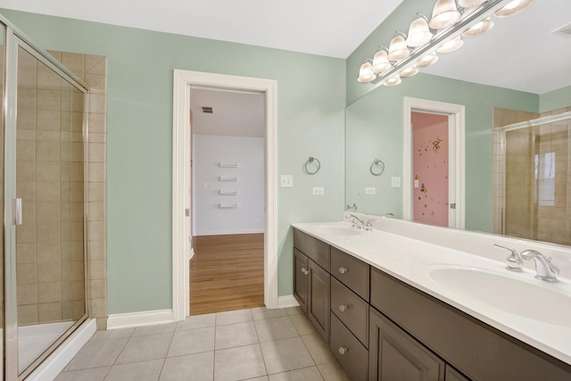 bathroom with tile patterned flooring, vanity, and an enclosed shower