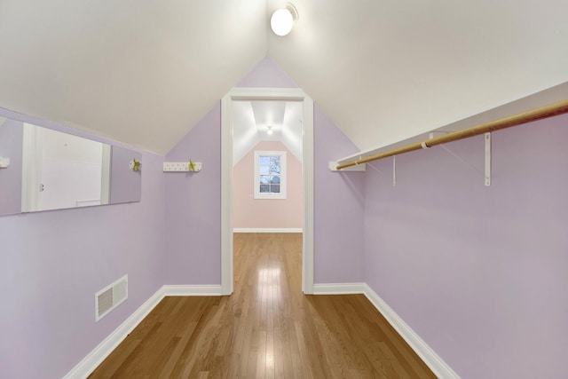 interior space featuring light wood-type flooring and vaulted ceiling