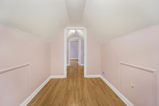 additional living space featuring light hardwood / wood-style flooring and lofted ceiling