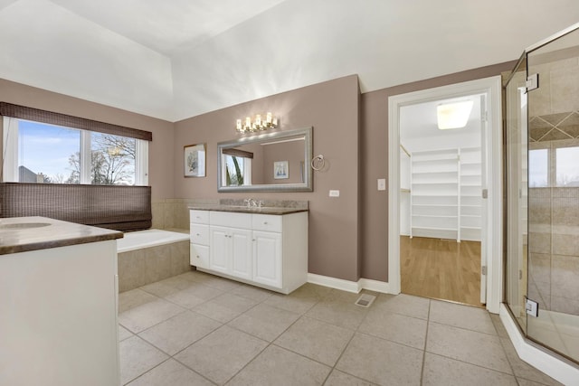 bathroom with tile patterned flooring, vanity, and shower with separate bathtub