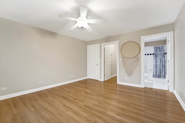 unfurnished bedroom featuring hardwood / wood-style flooring, ceiling fan, and connected bathroom