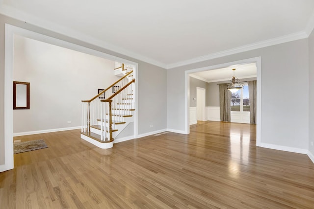 unfurnished living room featuring hardwood / wood-style flooring and crown molding