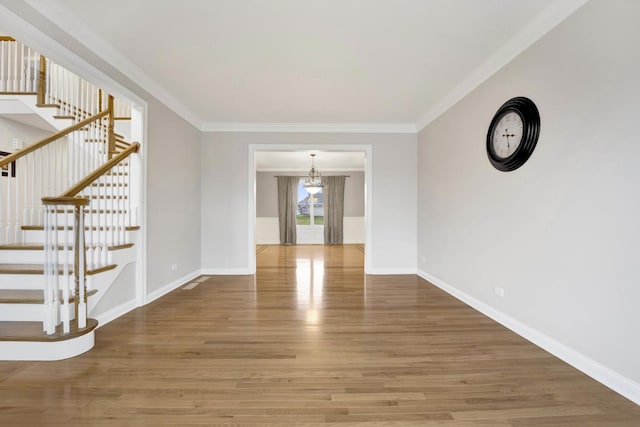 unfurnished living room with crown molding and hardwood / wood-style flooring