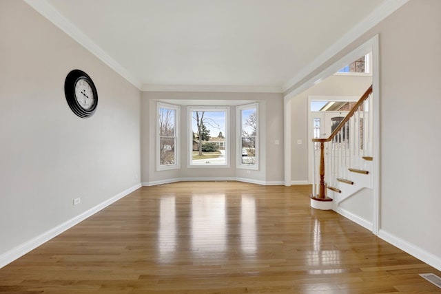 unfurnished living room featuring ornamental molding and hardwood / wood-style flooring