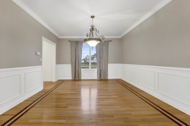 unfurnished dining area with light hardwood / wood-style floors, crown molding, and a chandelier