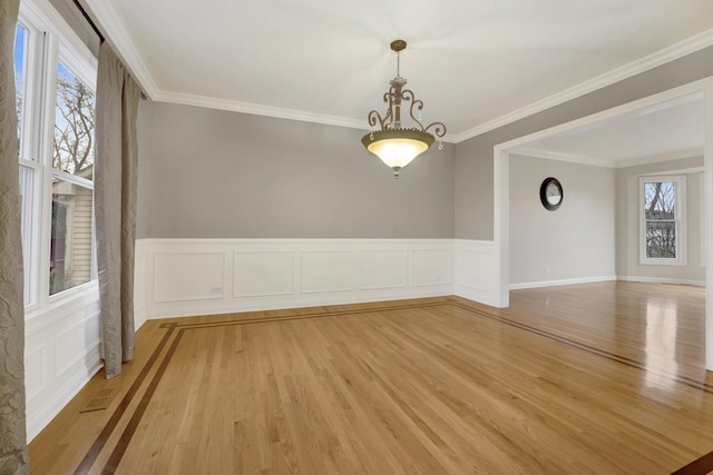 unfurnished room with light wood-type flooring and crown molding