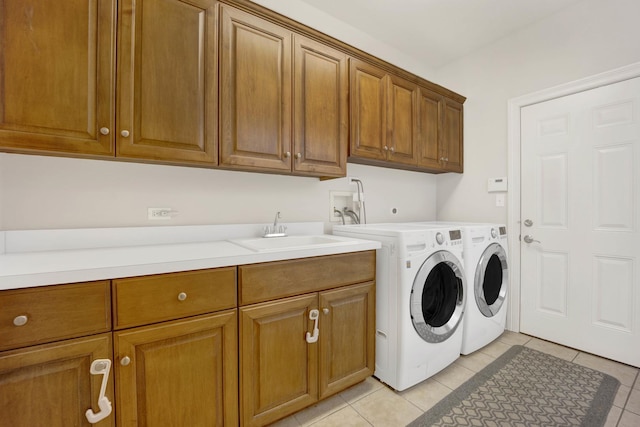 laundry room with separate washer and dryer, sink, light tile patterned floors, and cabinets