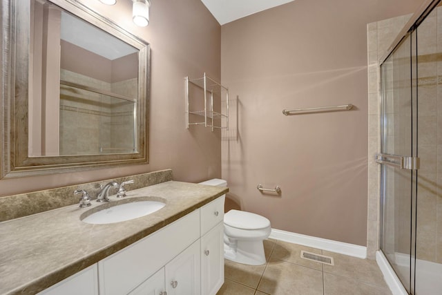 bathroom featuring toilet, vanity, tile patterned floors, and walk in shower