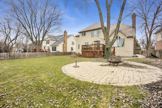 rear view of house featuring a yard, an outdoor fire pit, and a wooden deck