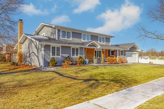 view of front of house featuring a front yard, a garage, and a porch