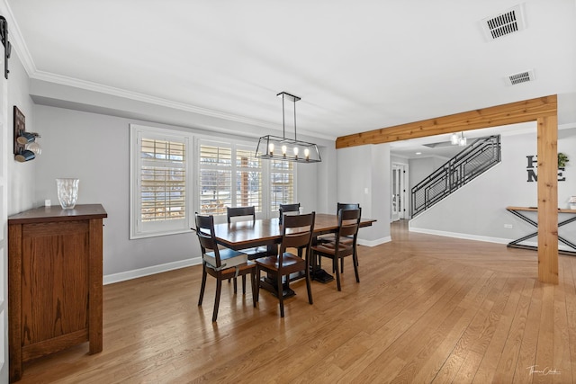 dining room with a chandelier, hardwood / wood-style floors, and crown molding