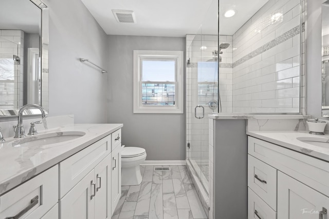 bathroom featuring vanity, a shower with shower door, and toilet